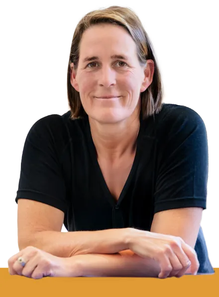Susanne Hartmann, Mediatorin, lächelnd an einem Tisch sitzend